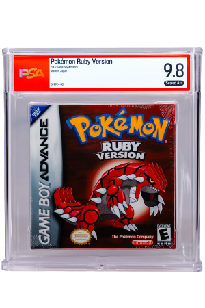 Close-up of a PSA-graded Pokémon Ruby Version Game Boy Advance cartridge in a protective case, label shows 'Pokémon Ruby Version' and grade '9.8 Sealed A++' against a red border, with visible cartridge art beneath.