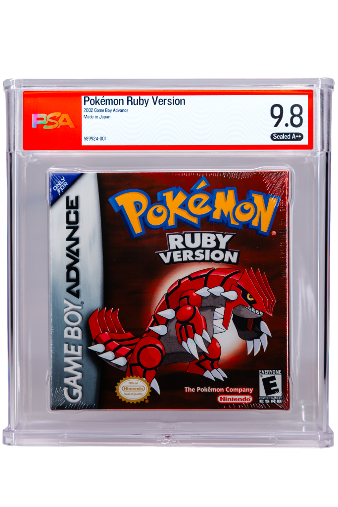 Close-up of a PSA-graded Pokémon Ruby Version Game Boy Advance cartridge in a protective case, label shows 'Pokémon Ruby Version' and grade '9.8 Sealed A++' against a red border, with visible cartridge art beneath.